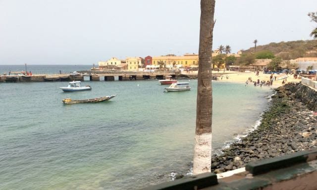 The ocean and beach with small boats in the water.